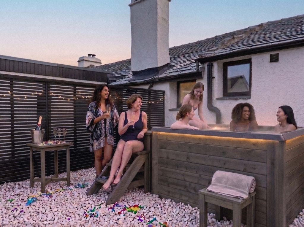 Group of women celebrating with champagne outside one of our hen party houses with hot tubs.